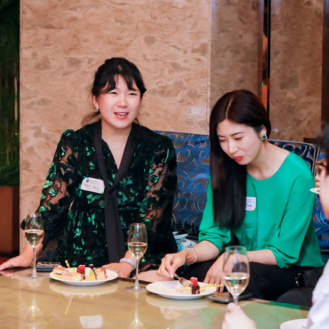 Two UCD alumnae at a global event, having some refreshments.